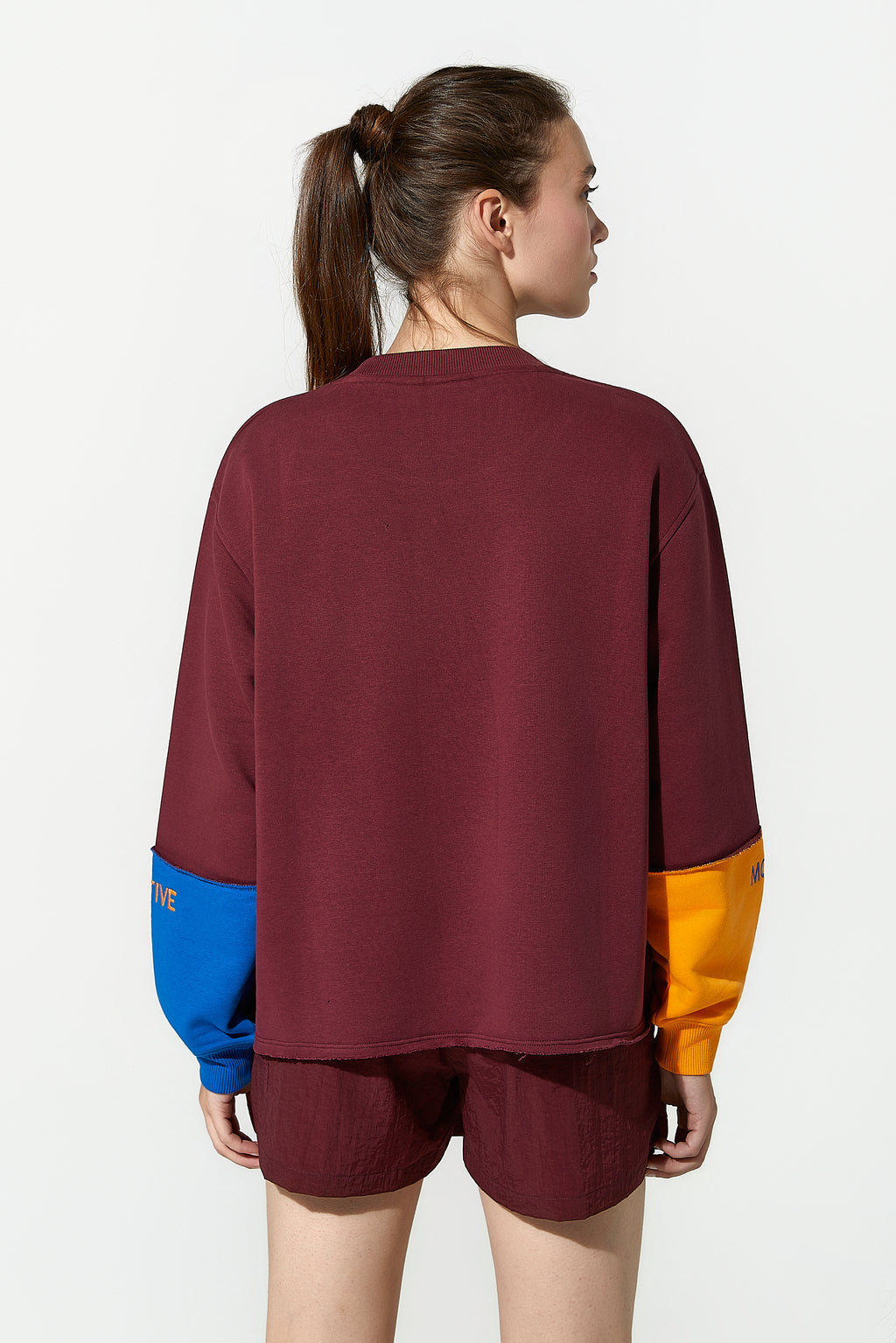 A model wearing a burgundy oversized sweatshirt