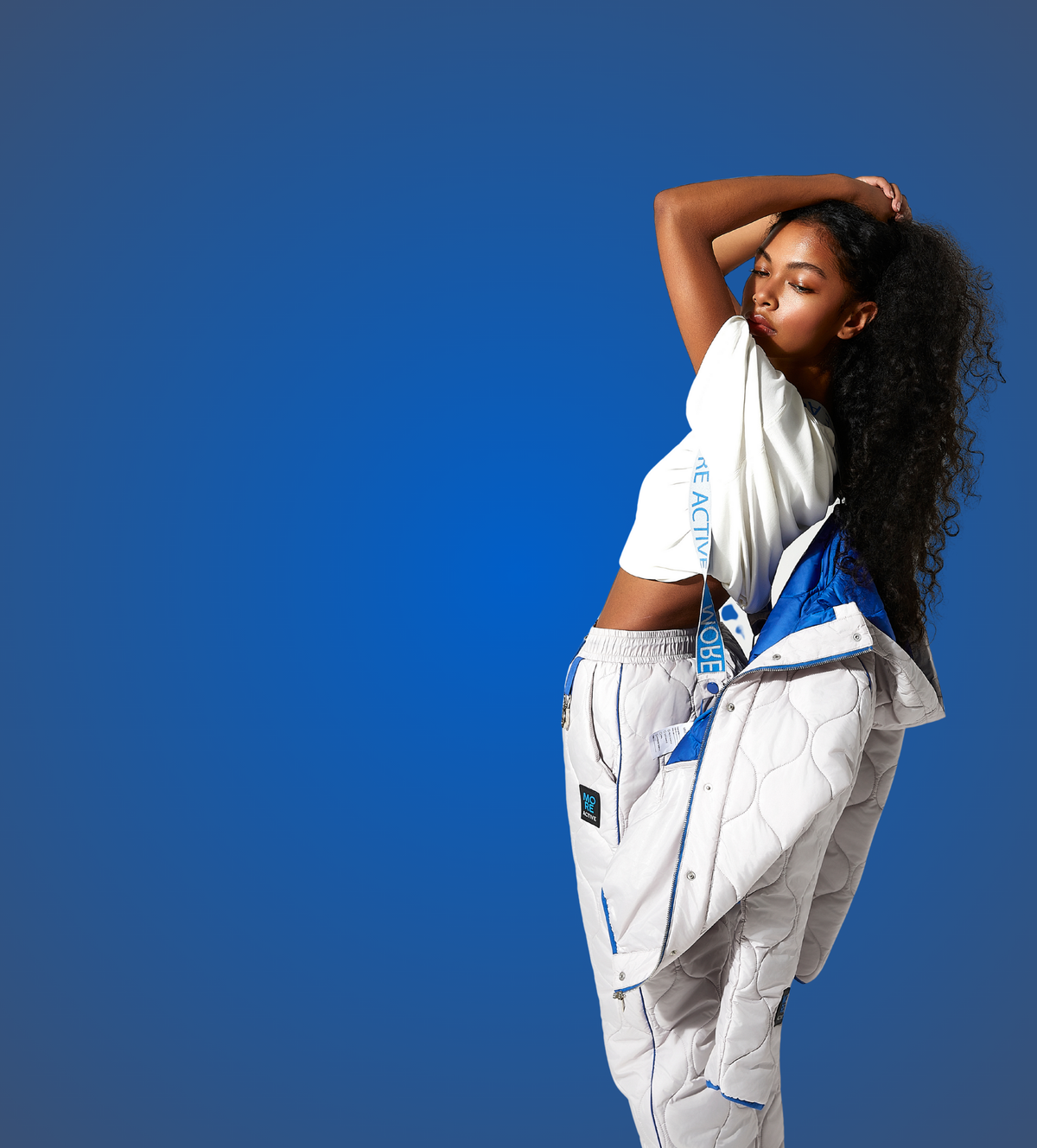 Person wearing a white outfit with blue accents against a blue background