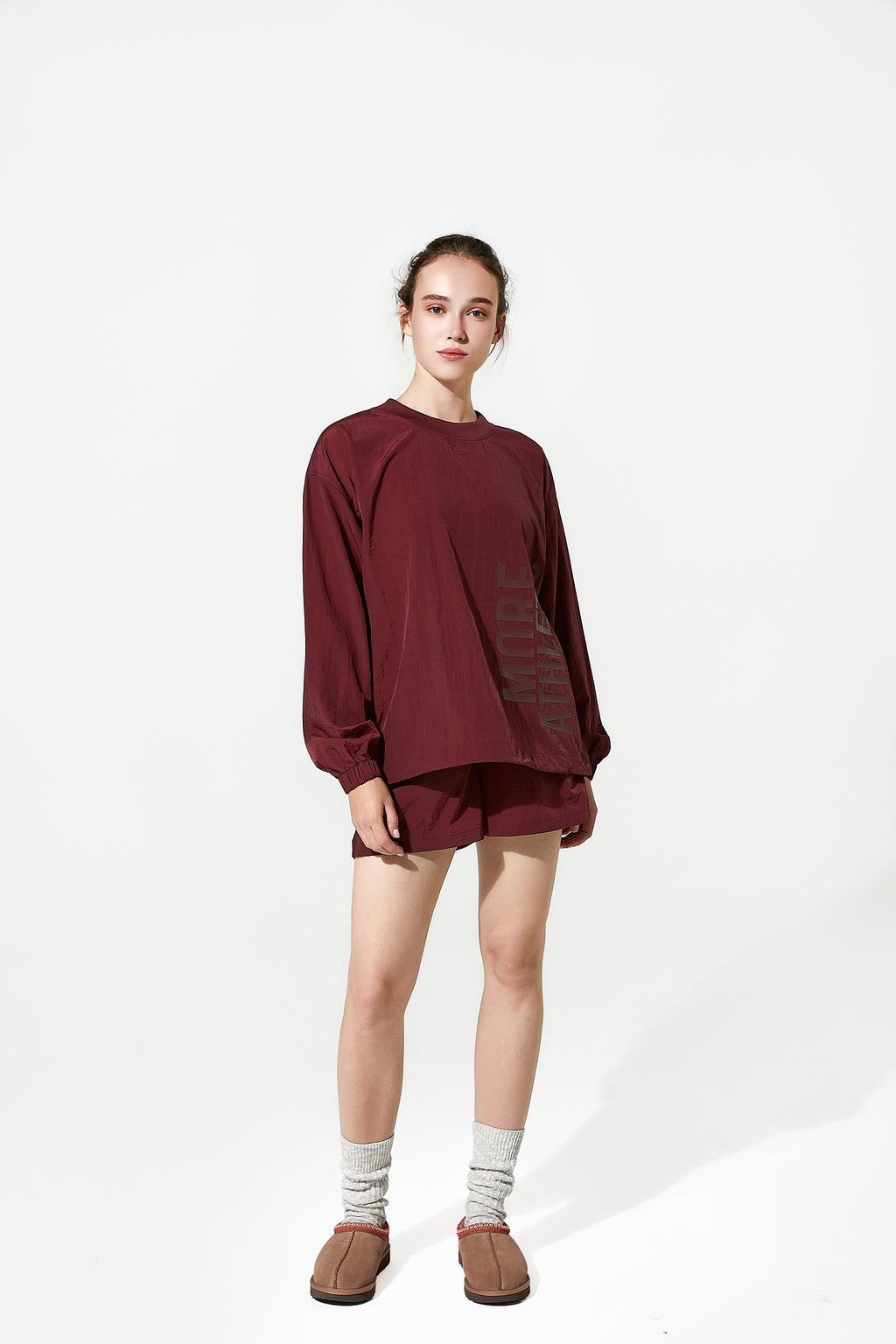 Modern sports set featuring windbreakers for women and functional sports shorts, showcasing a relaxed-fit womens windbreaker in a rich burgundy tone