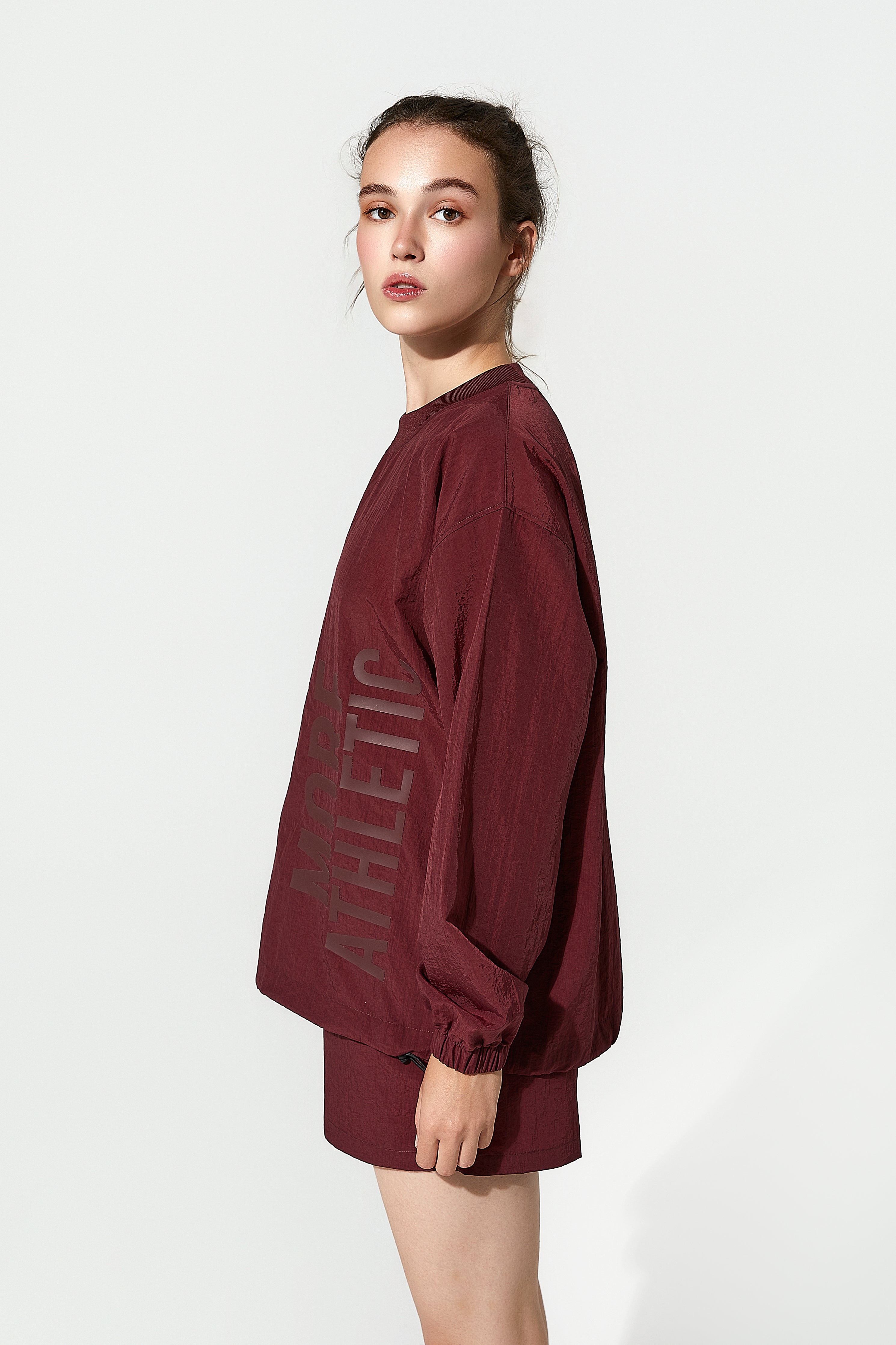 Stylish burgundy windbreakers for women paired with matching sports shorts, highlighting the More Active womens windbreaker for dynamic movement