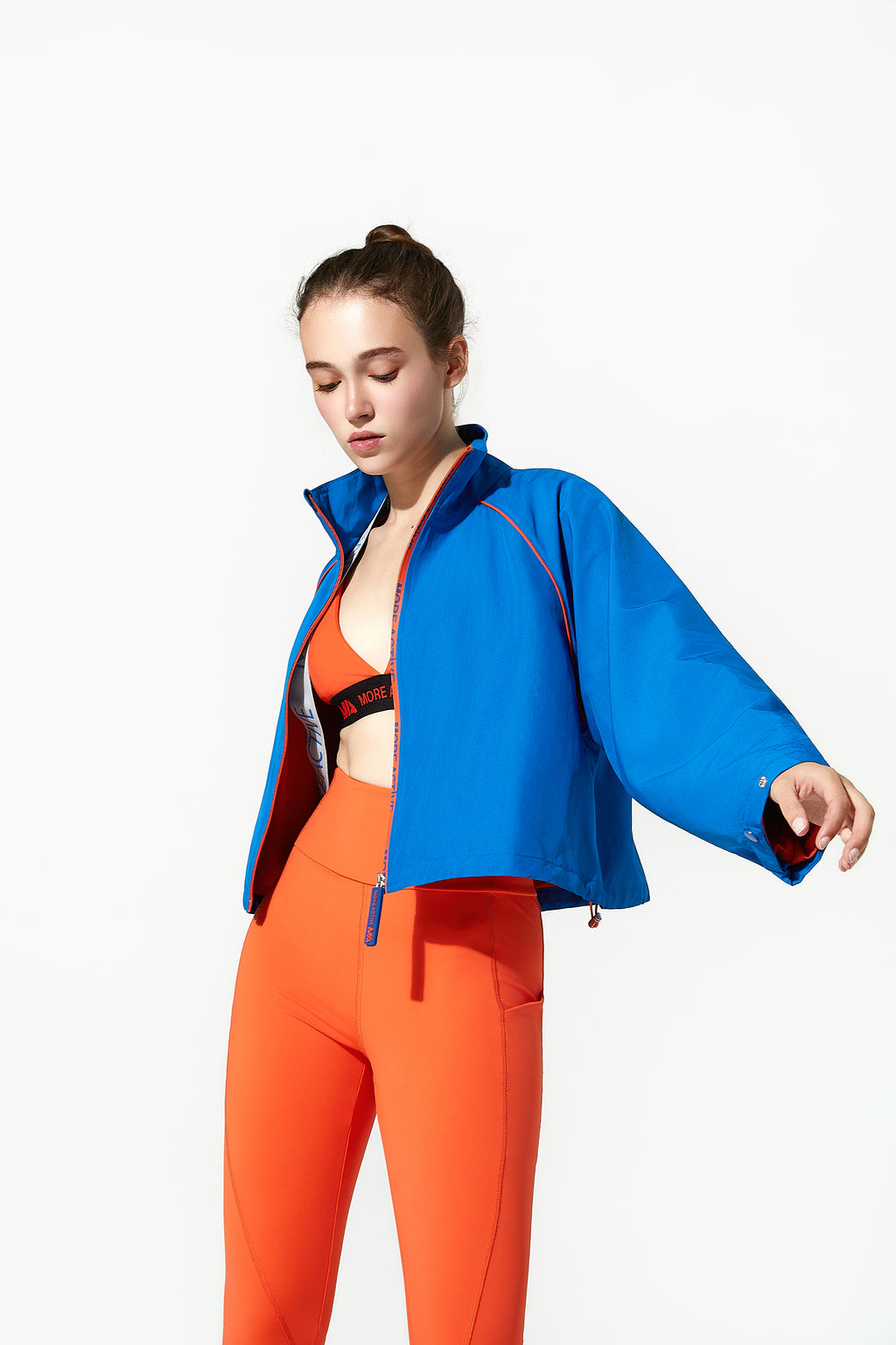 Woman wearing a blue  cropped coat jacket and orange pants