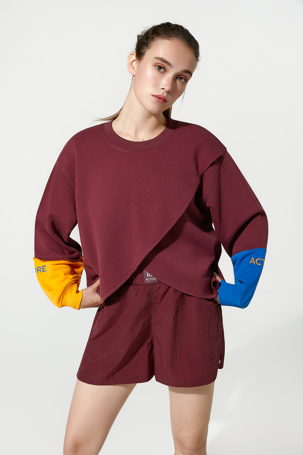 Woman wearing a burgundy outfit Track top and windbreaker shorts