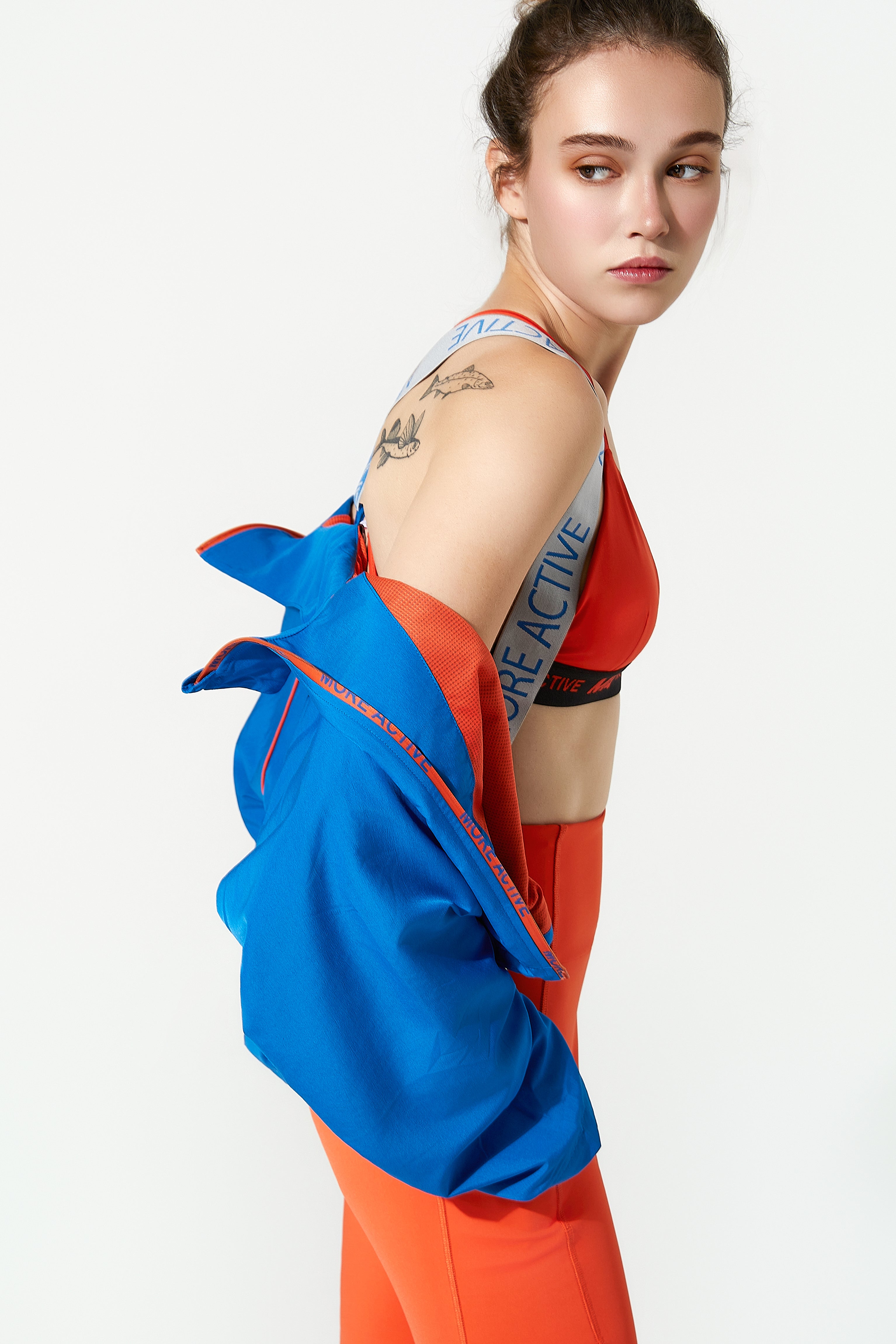 Woman wearing a colourful outfit with a blue jacket womens spring and orange design on a white background