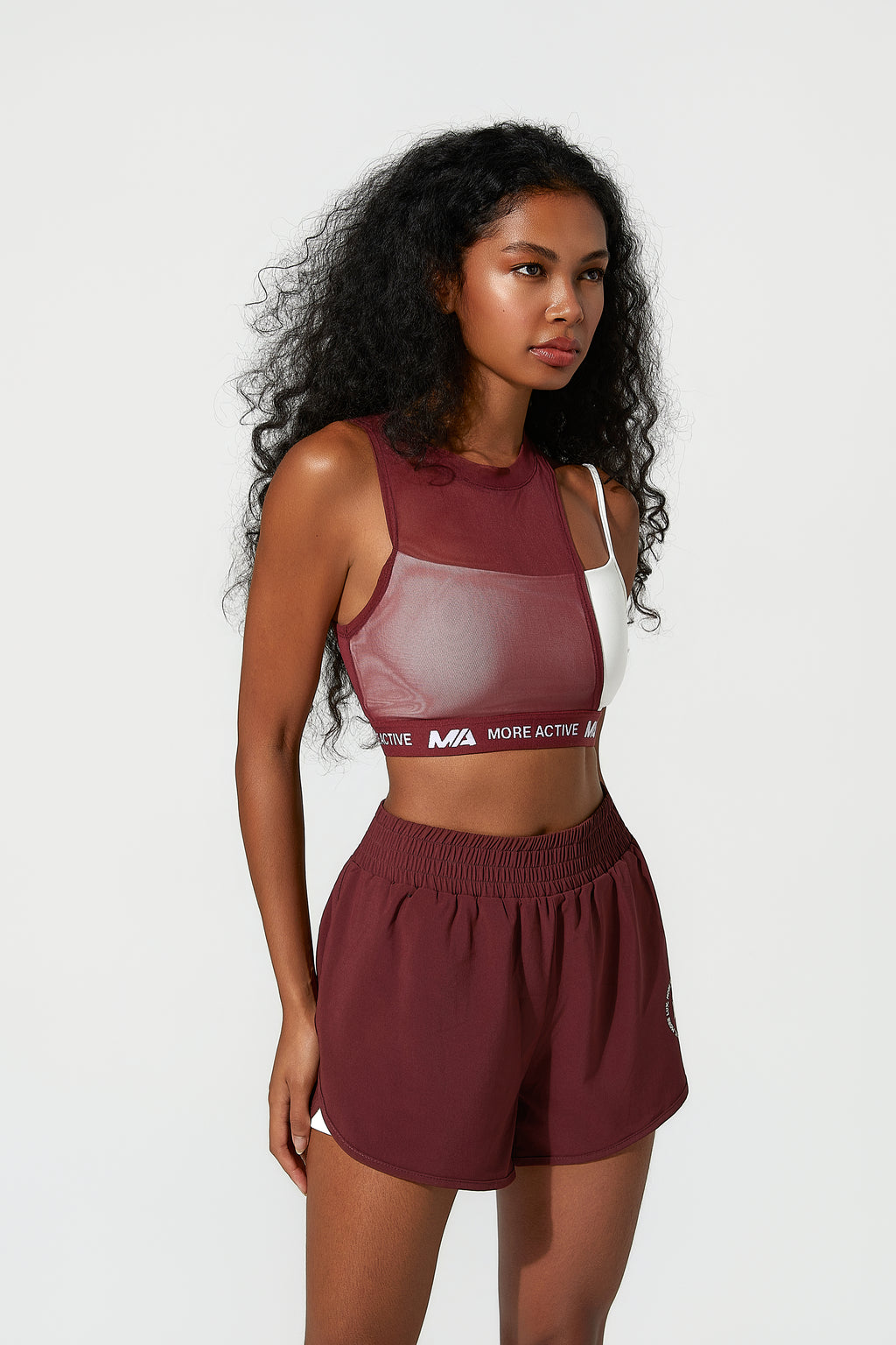 Woman wearing a maroon ladies work shorts​ with a visible brand logo on a white background - Running Shorts