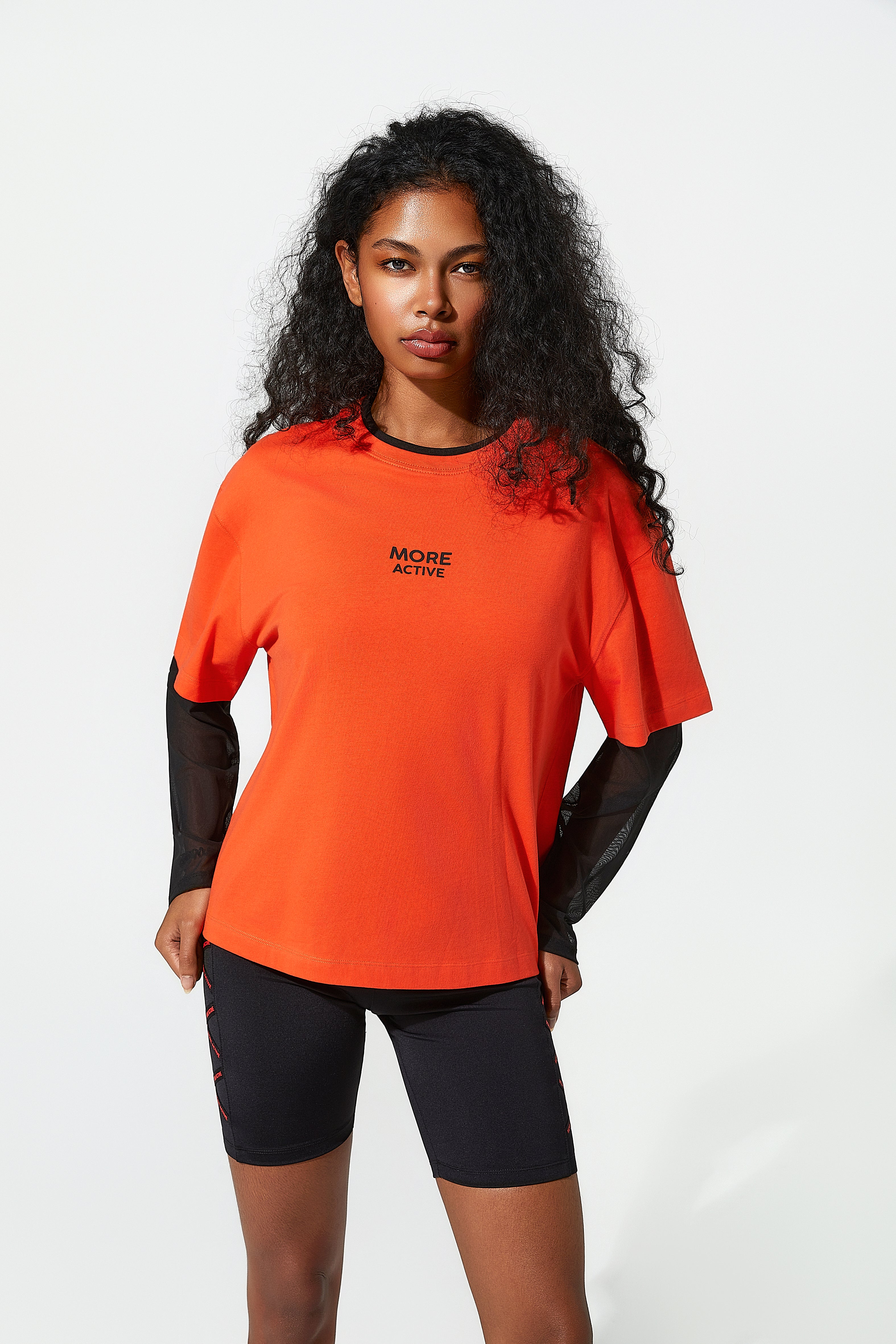 Woman wearing an orange athletic gymnasium t shirt with 'More Active' text on a white background