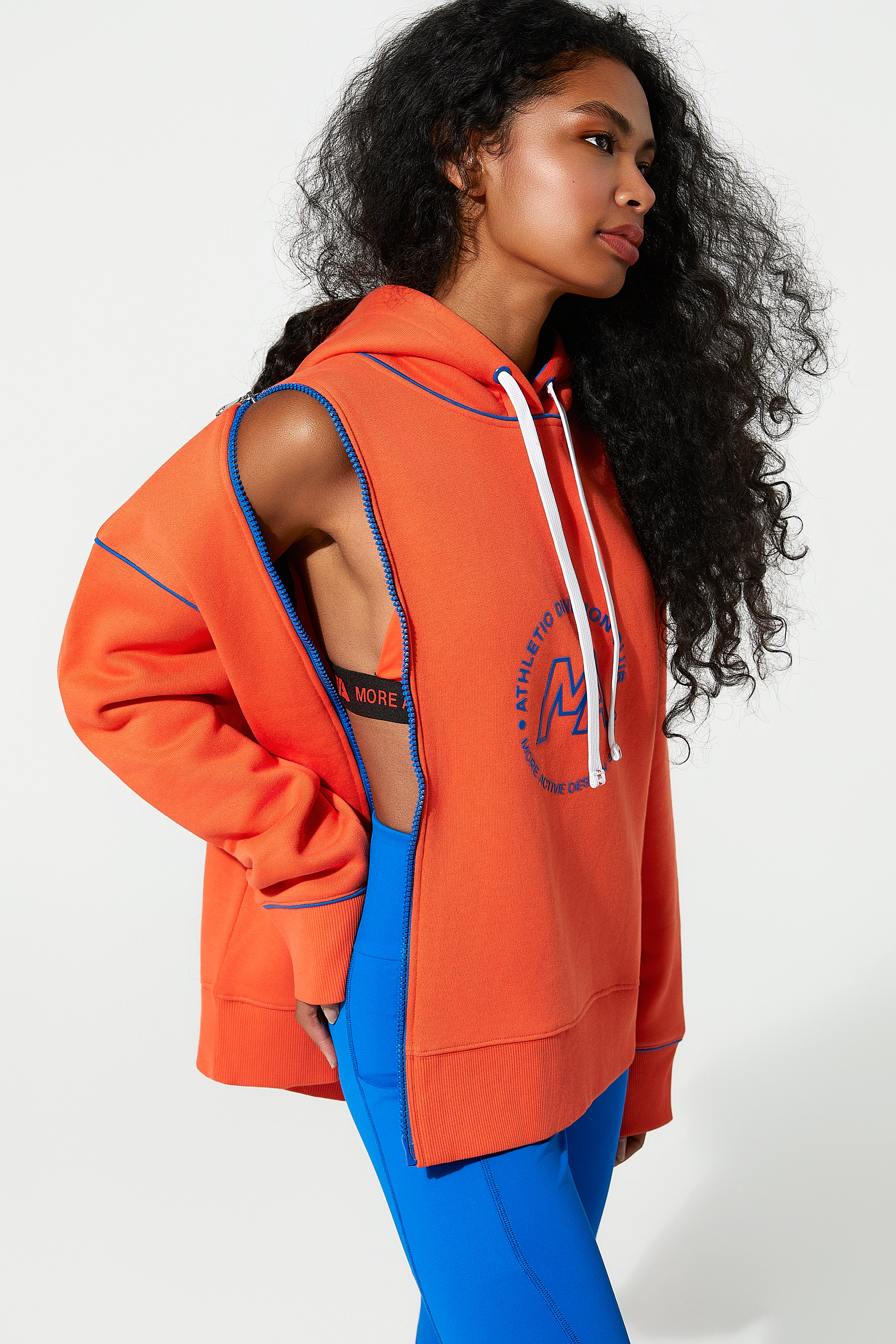 Woman wearing an orange ladies zip up hoodies with cut-out design