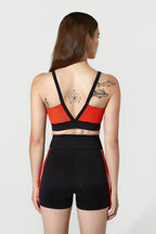 Woman wearing a black and red sports outfit with tattoos visible on her back.