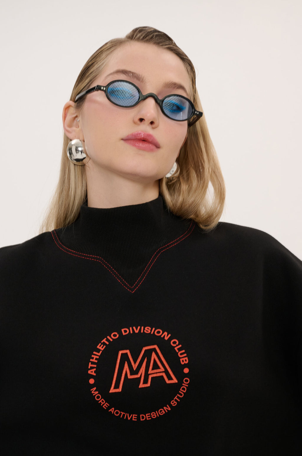 Person wearing a black sweatshirt with red text and logo on a white background