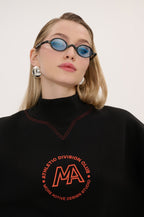 Person wearing a black sweatshirt with red text and logo on a white background