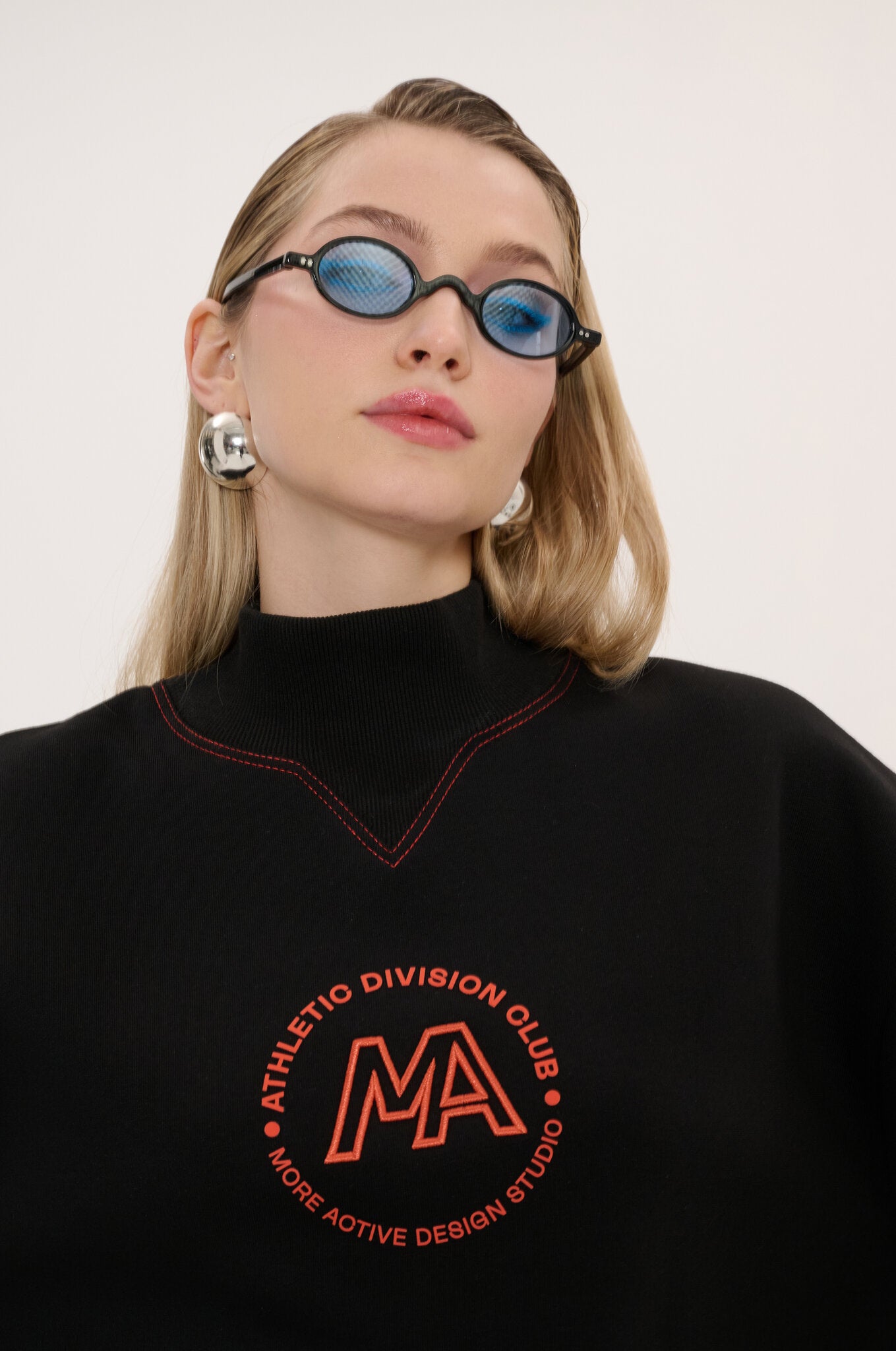 Person wearing a black sweatshirt with red text and logo on a white background