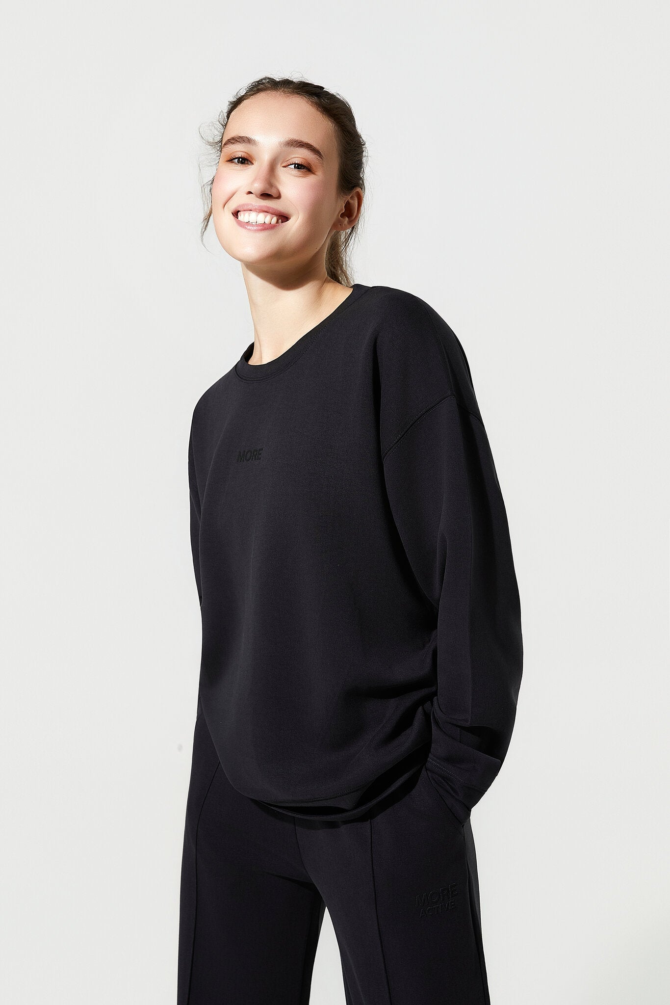 Person wearing a black outfit on a plain background