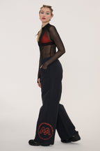 Woman wearing a black dress with sheer panels on a white background