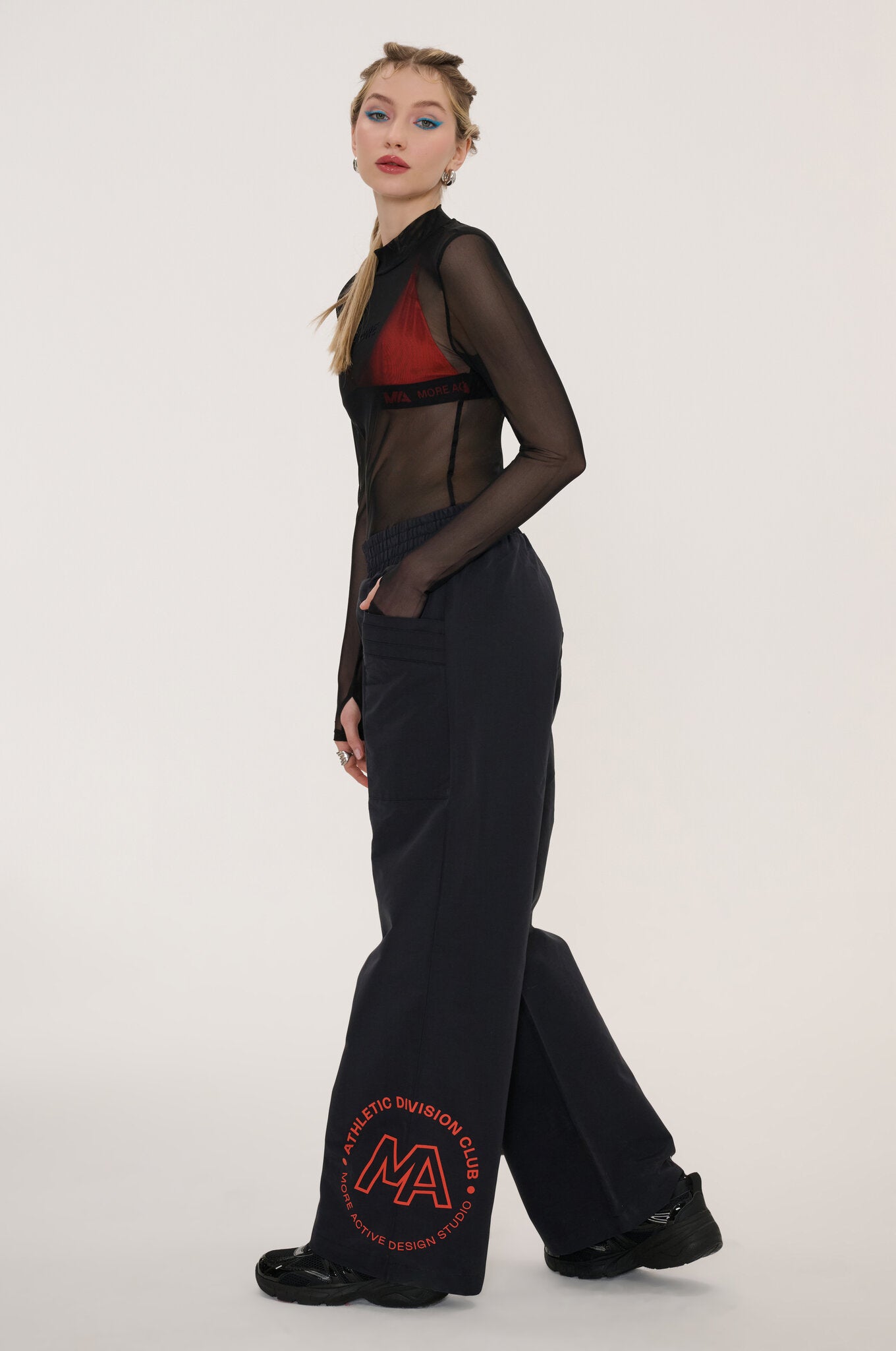 Woman wearing a black dress with sheer panels on a white background