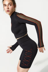 Person wearing a black outfit with red accents on a white background