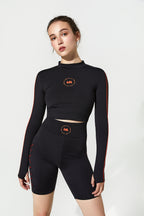 Person wearing a black athletic outfit with red accents on a white background