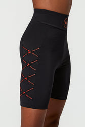 Black athletic biker shorts with red 'MORE ACTIVE' text and logo details, shown on a model against a light gray background.