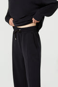 Person wearing a black outfit with a plain background
