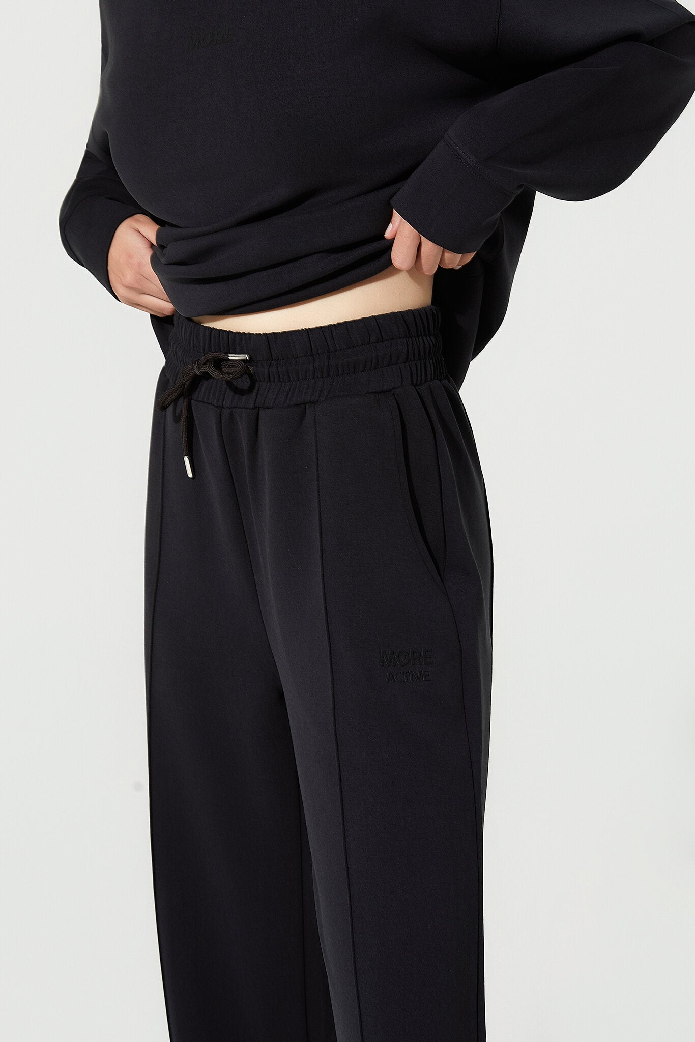 Person wearing a black outfit with a plain background