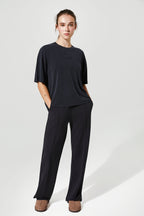 Person wearing a black outfit on a white background