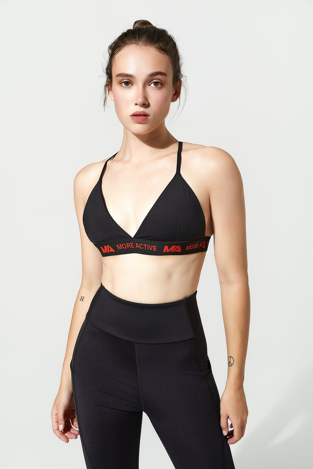 Woman wearing a black sports bra and leggings with 'More Active' branding on a white background