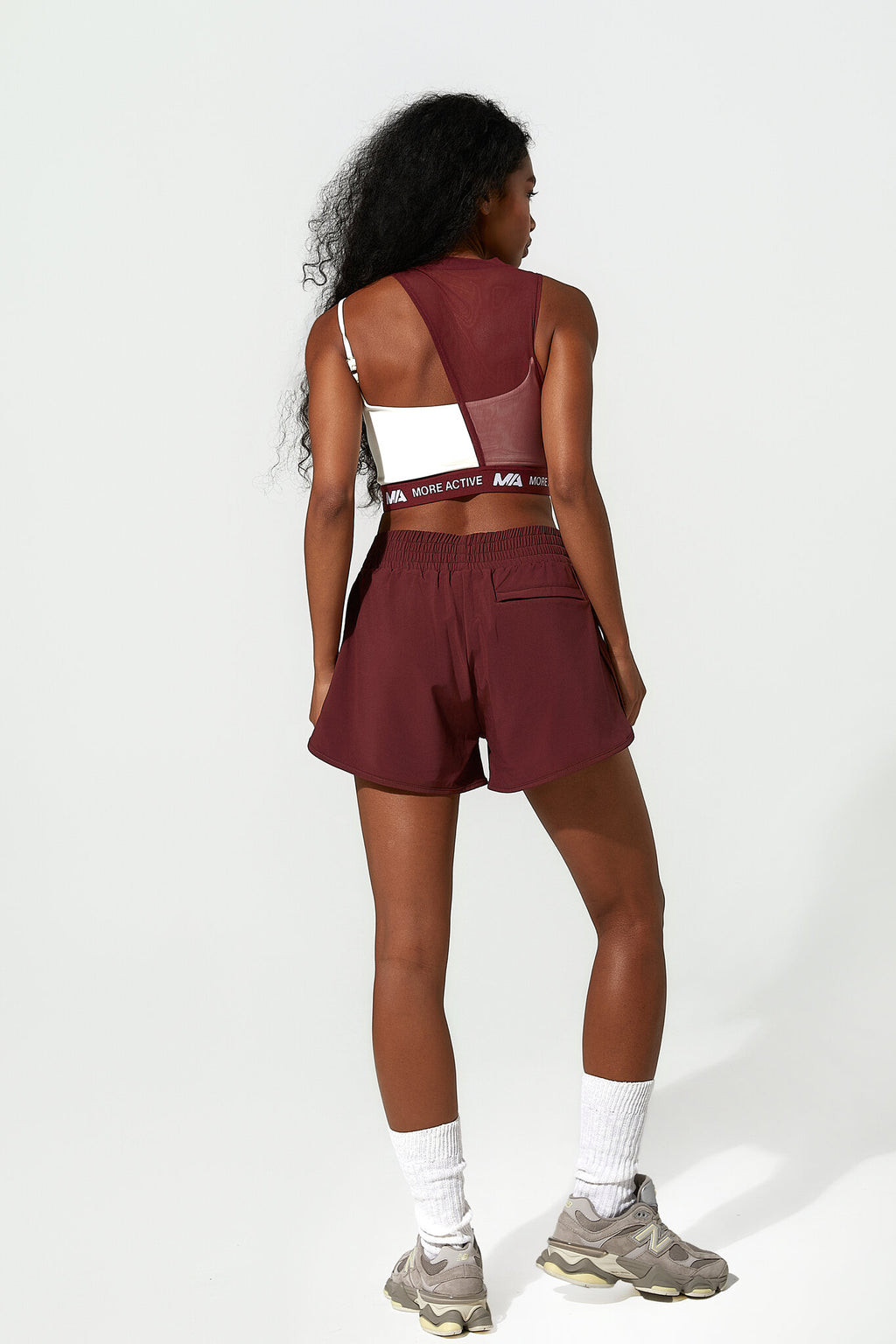 Person wearing a maroon athletic outfit with a white background