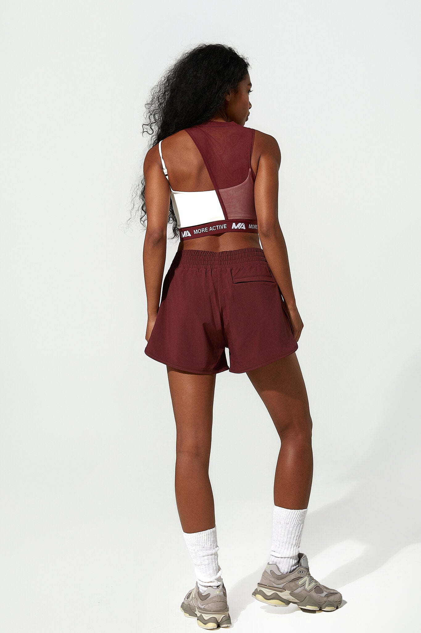 Person wearing a maroon athletic outfit with a white background