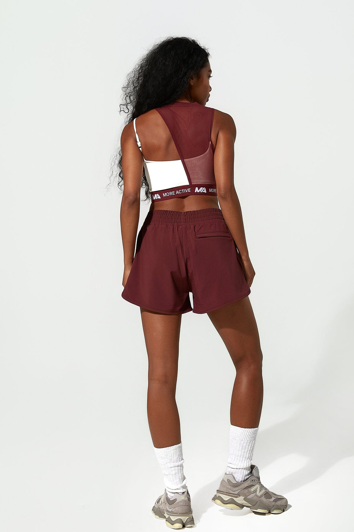 Person wearing a maroon athletic outfit with a white background