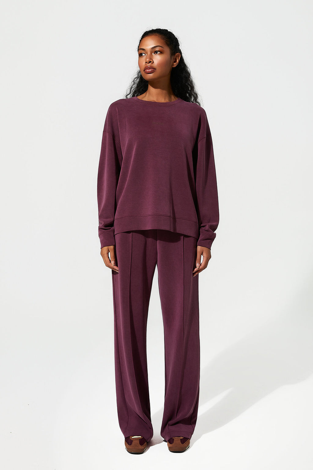 Woman wearing a burgundy outfit on a white background
