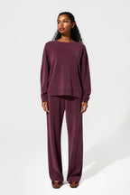 Woman wearing a burgundy outfit on a white background