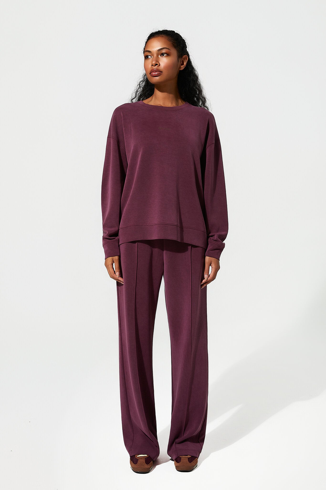 Woman wearing a burgundy outfit on a white background