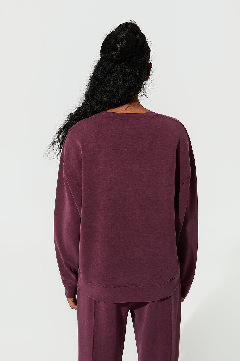 Person wearing a maroon outfit on a white background