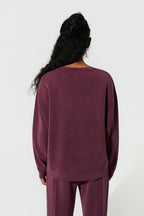 Person wearing a maroon outfit on a white background