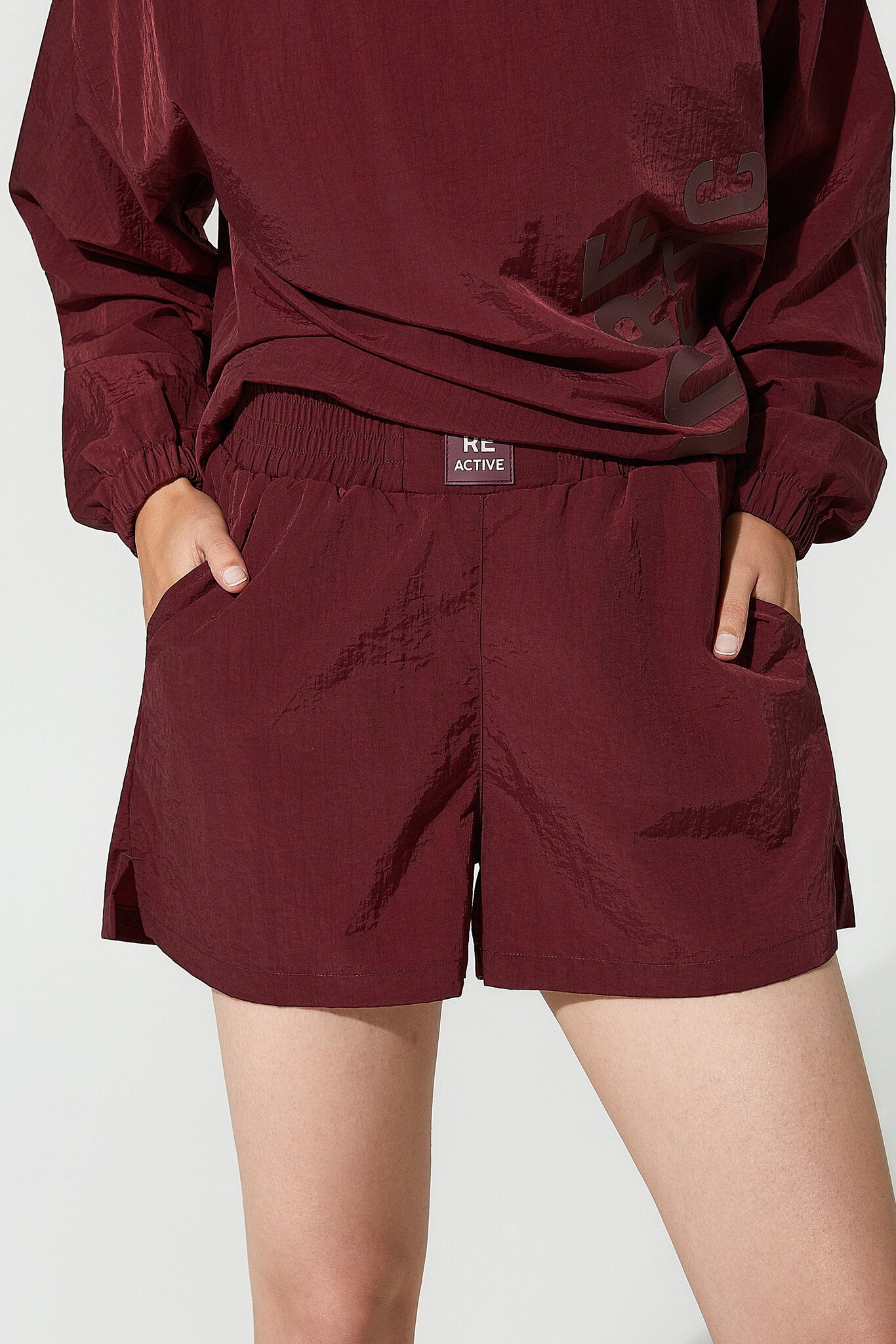 Maroon tracksuit with shorts on a light gray background