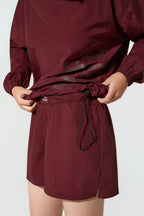 Maroon short with a belt on a white background