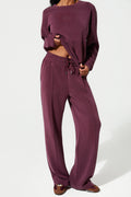Person wearing a burgundy loungewear set on a white background