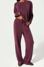 Person wearing a burgundy loungewear set on a white background