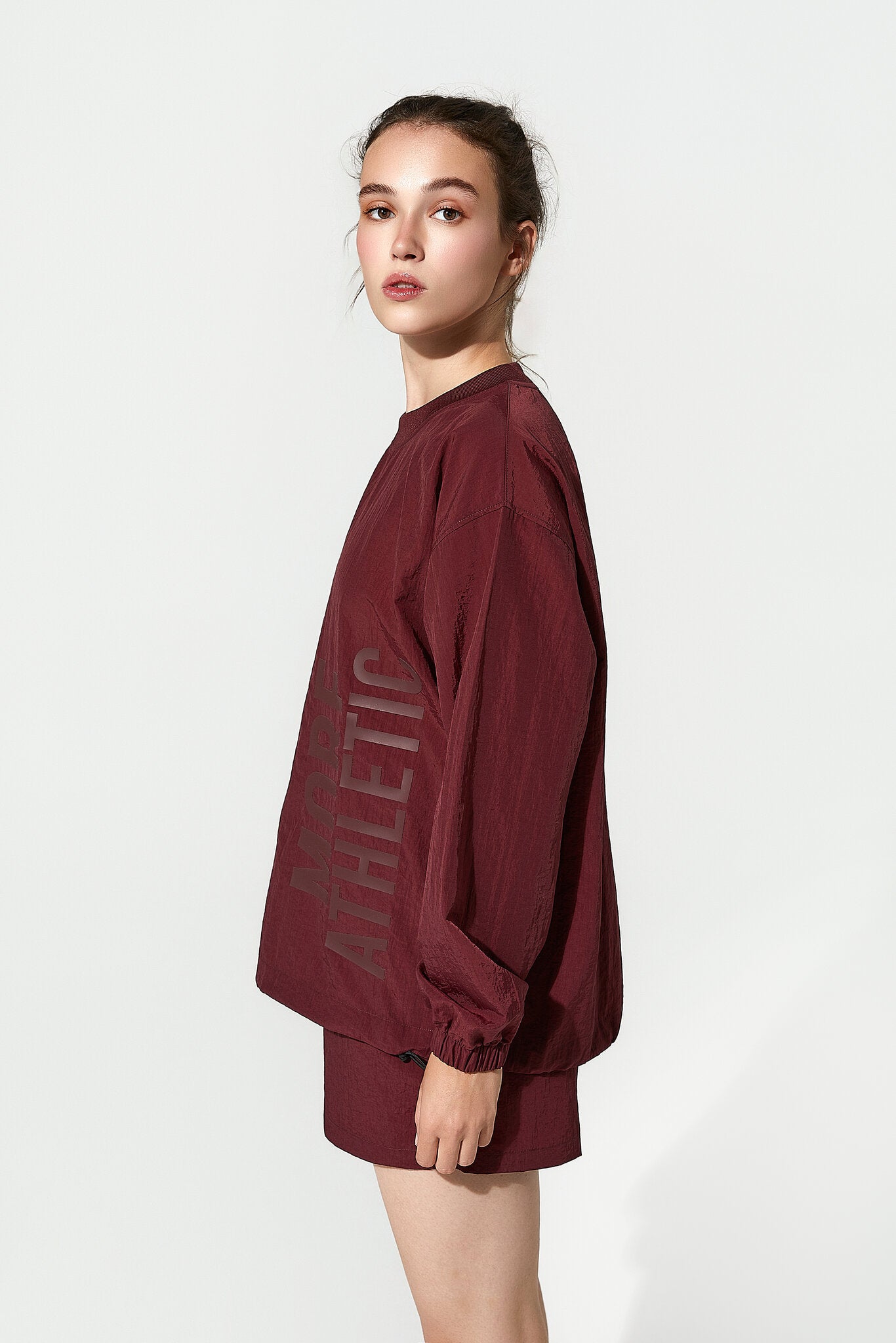 Person wearing a maroon athletic outfit on a white background