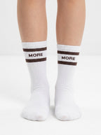 Model wearing white half-crew throwback socks with a chocolate brown double stripe
