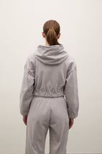 Person wearing a gray tracksuit from behind on a white background