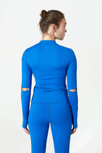 Person wearing a blue outfit with cut-out details on a white background