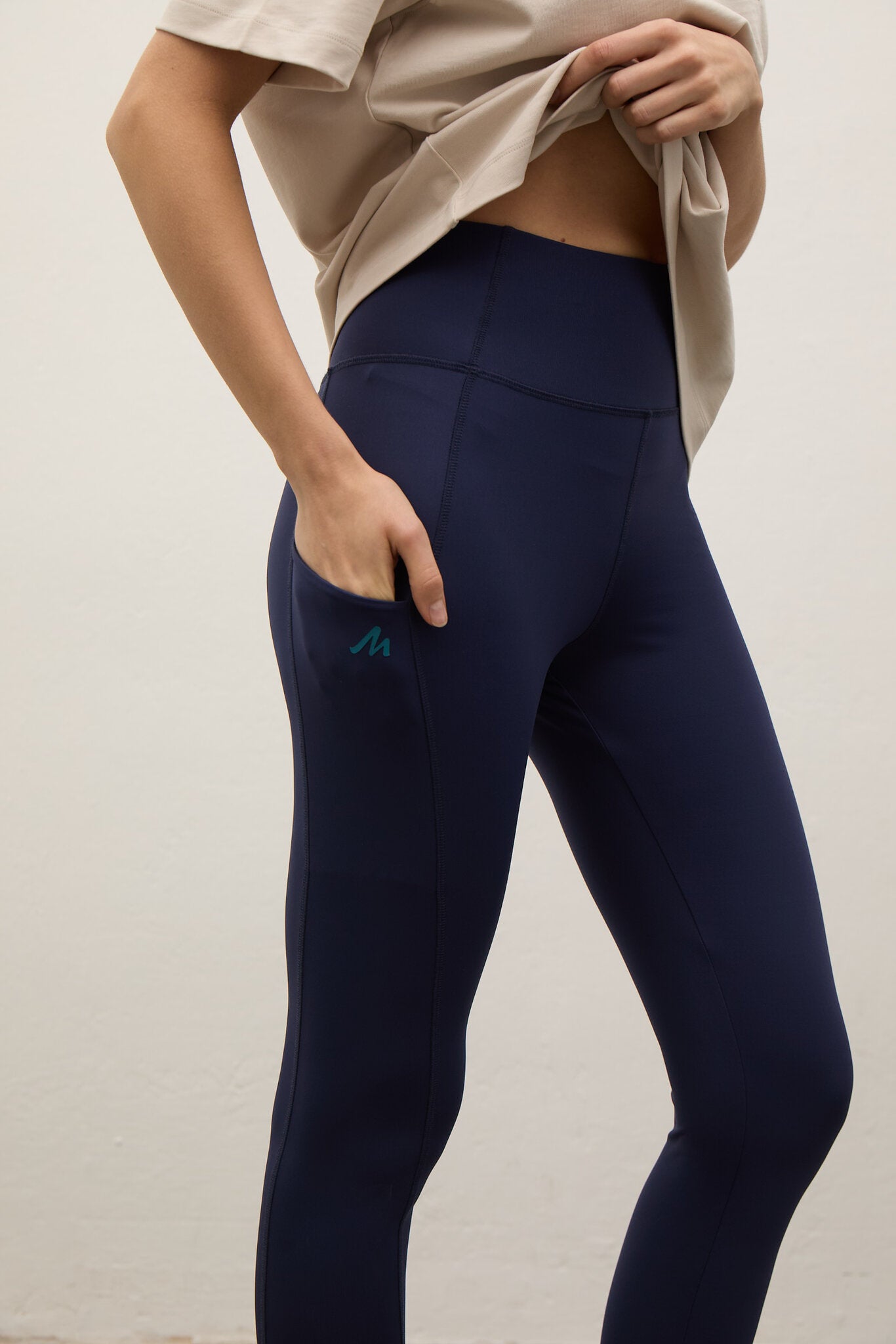 Navy leggings with a small logo on a plain background