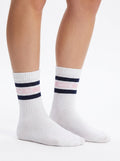 Model wearing white half-crew throwback socks with a maritime blue and ballerina pink double stripe