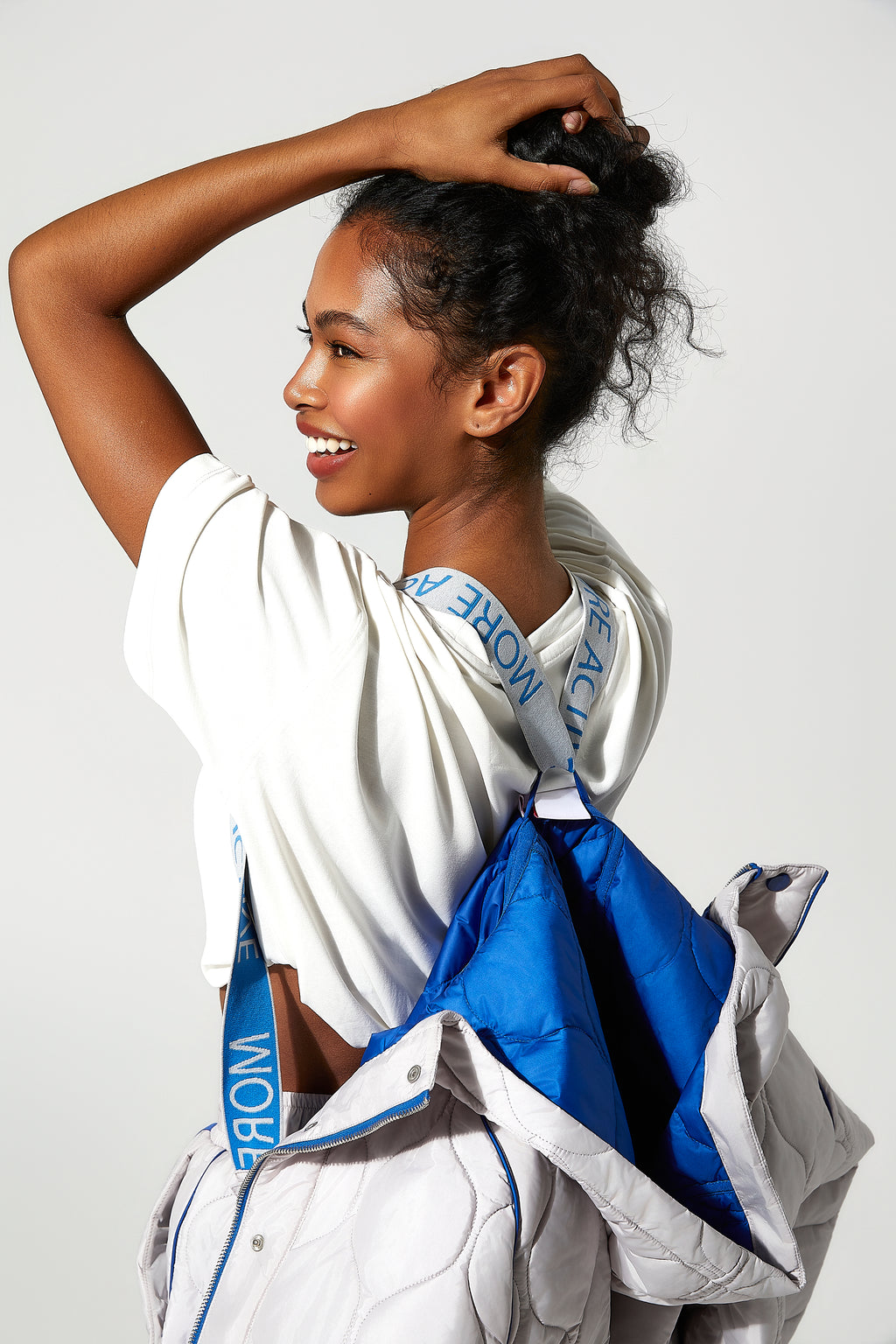 model wearing a Ice white and blue womens puffer jacket with visible  More Active branding straps.