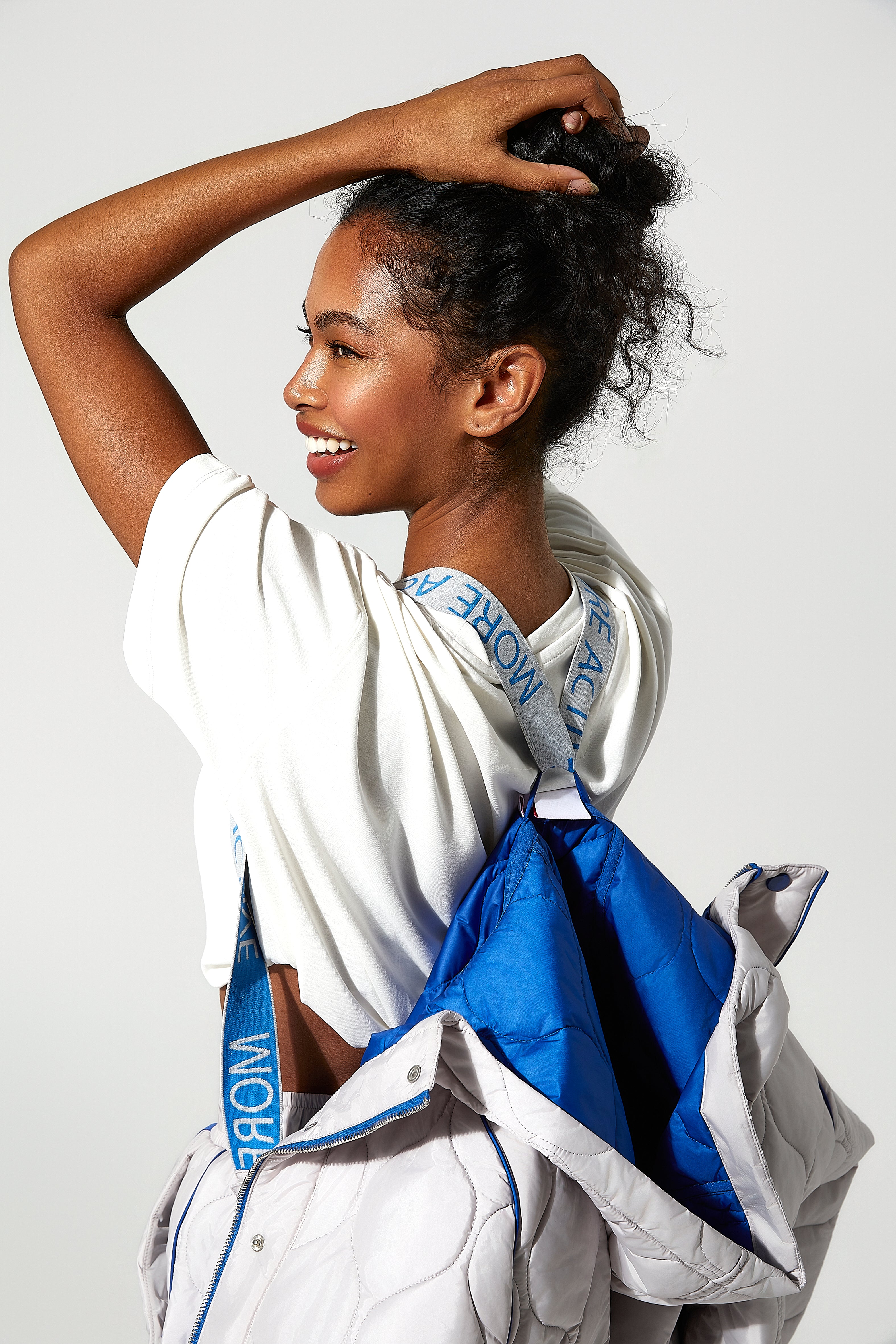 model wearing a Ice white and blue womens puffer jacket with visible  More Active branding straps.