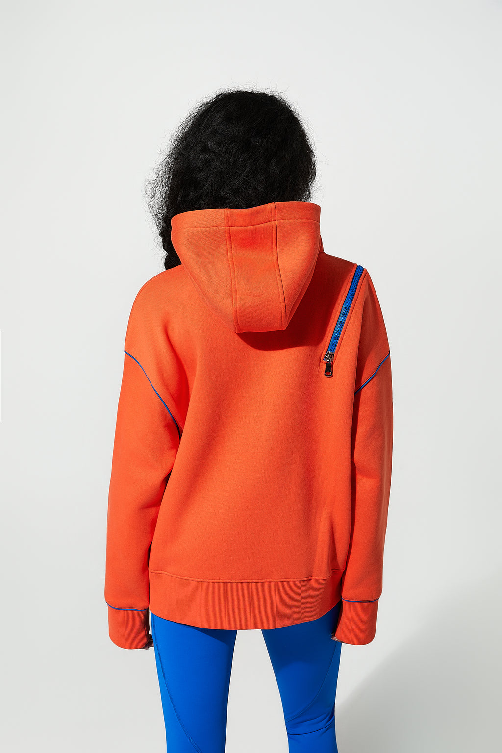 model wearing an orange womens sweatshirts with a white background