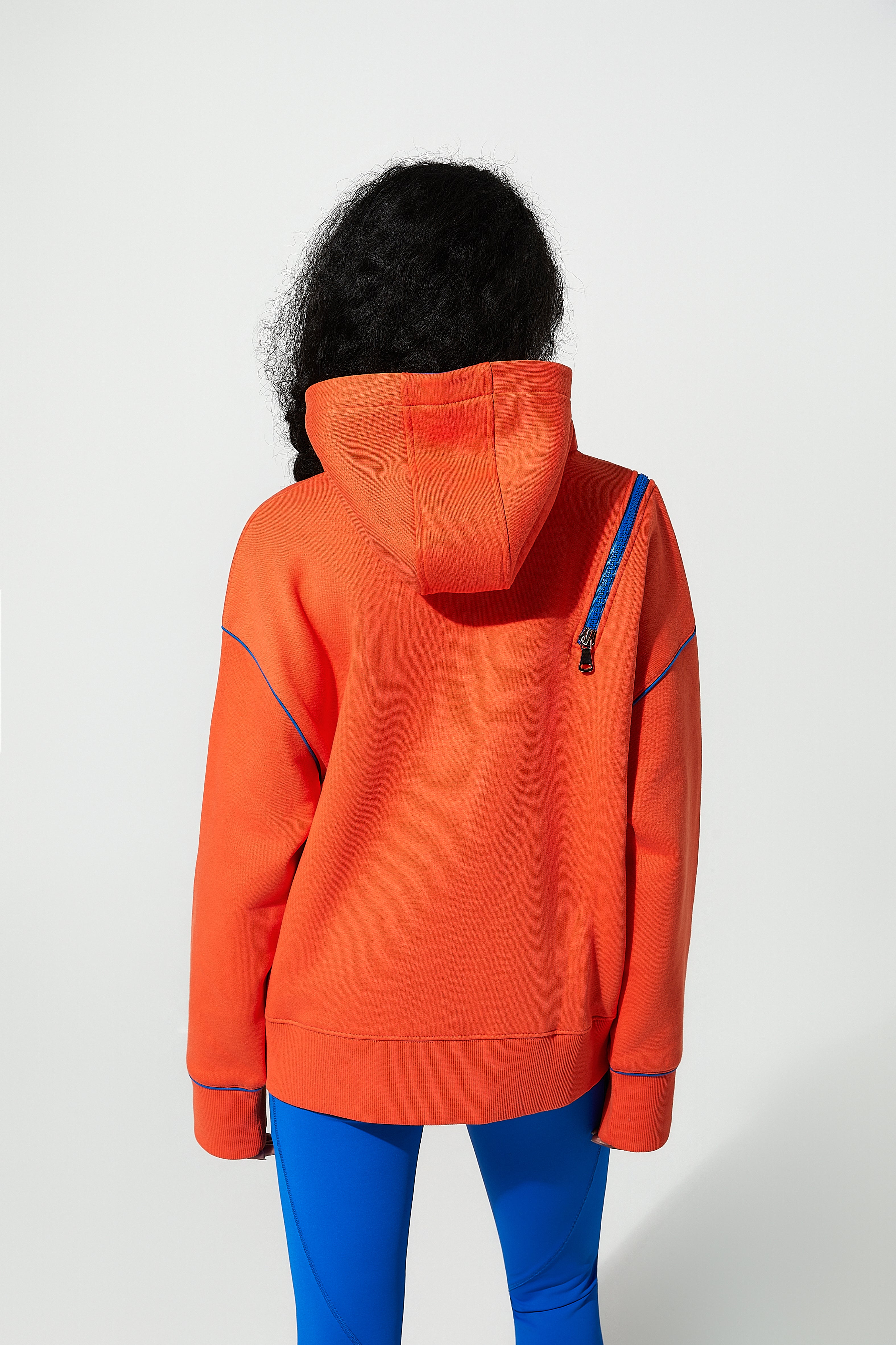 model wearing an orange womens sweatshirts with a white background
