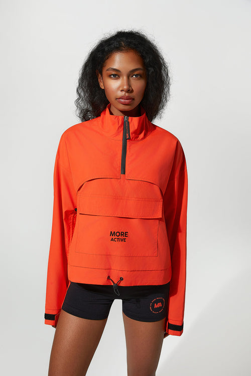 Person wearing an orange jacket with a brand logo on a white background