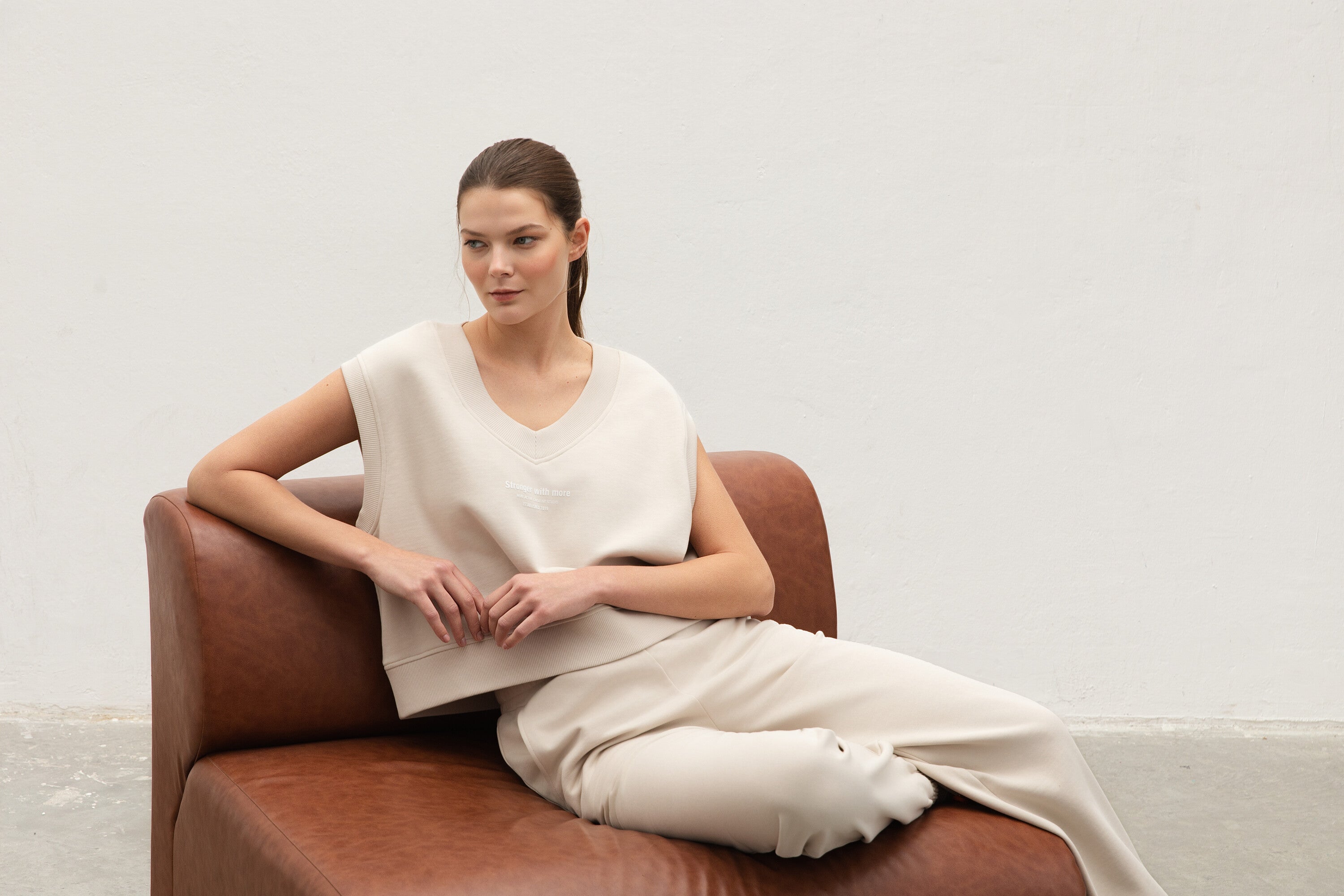 Cuffed Fleece Jogger Pumice Stone Lifestyle_sleeveless jumper​ model sitting on couch
