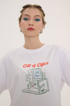 Person wearing a white sweatshirt with a graphic design and text 'Out of Office' on a plain background